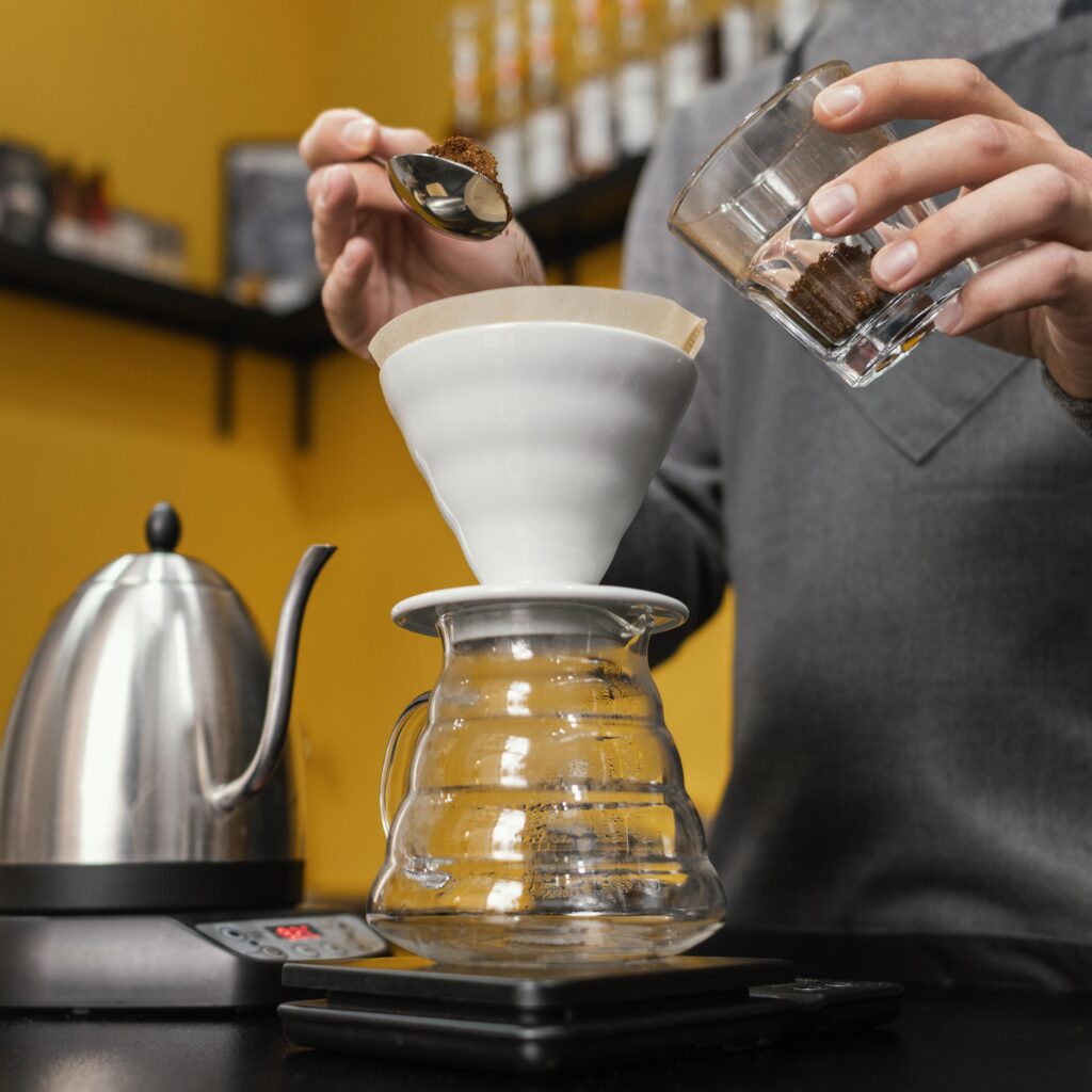 angulo-bajo-de-barista-macho-poniendo-cafe-en-el-filtro